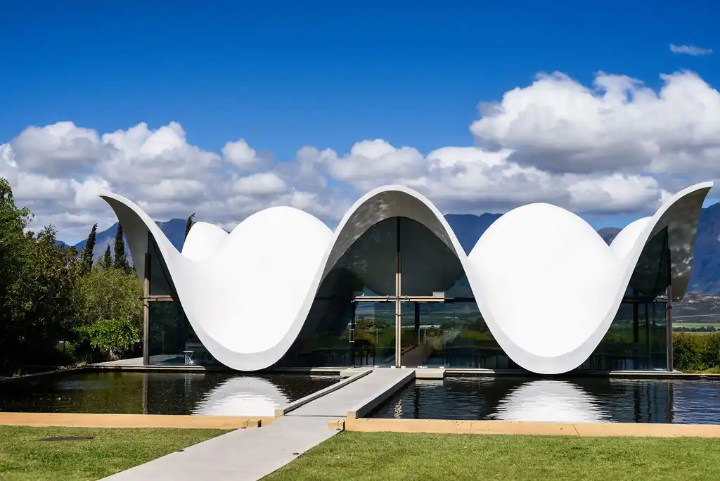 Bosjes Chapel's white wave-shaped roof reflected in the pool, Western Cape — One Day Africa travel blog