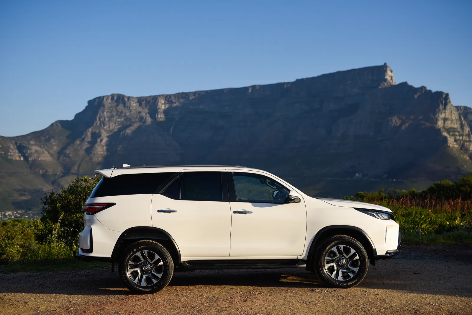 Side view of the One Day Africa 7-seater Toyota Fortuner with Table Mountain behind